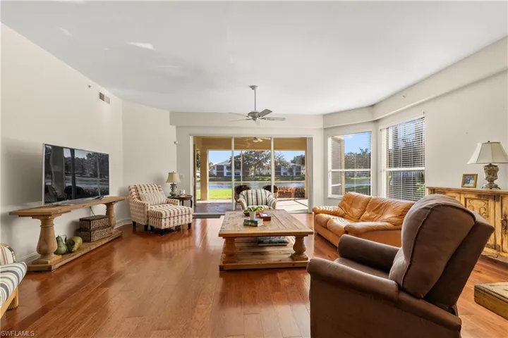 Living room with hardwood / wood-style floors, healthy amount of natural light, and a ceiling fan