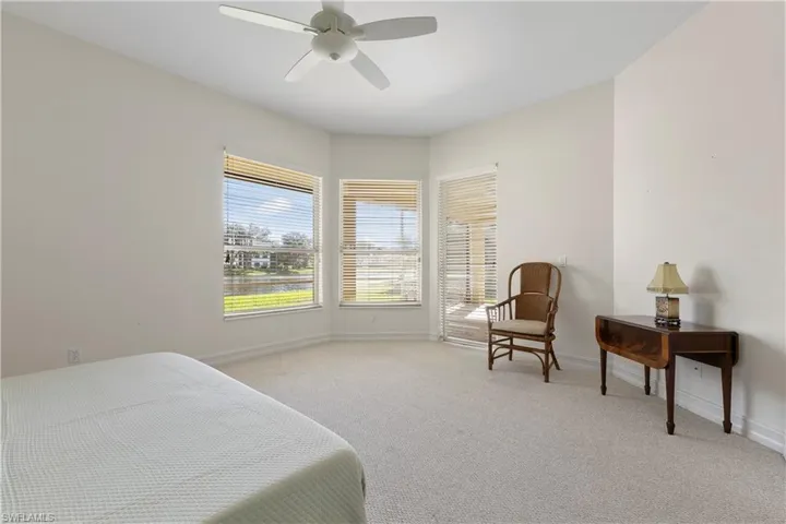 Bedroom with light colored carpet and a ceiling fan