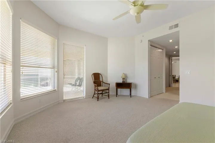Bedroom with light carpet, a ceiling fan, and a closet