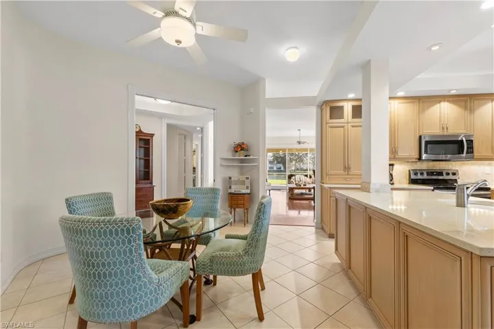 Dining area with a ceiling fan, light tile patterned floors, and recessed lighting