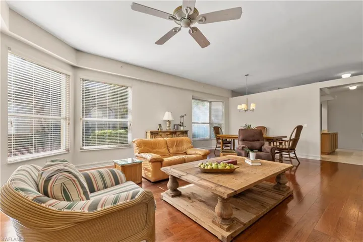 Living area featuring hardwood / wood-style flooring, a ceiling fan, and a chandelier