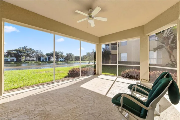Sunroom / solarium featuring a ceiling fan and a water view