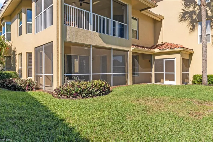 Back of property with stucco siding, a yard, ceiling fan, and a sunroom