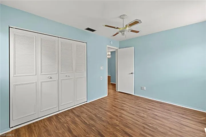 Unfurnished bedroom featuring a closet, ceiling fan, and hardwood / wood-style flooring