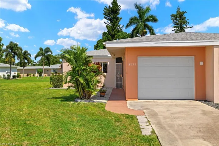 Ranch-style house with a front yard and a garage
