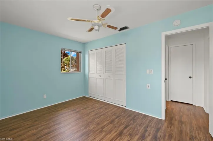 Unfurnished bedroom featuring ceiling fan, dark hardwood / wood-style floors, and a closet