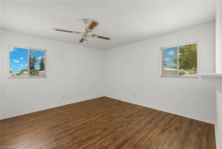 Spare room featuring plenty of natural light, ceiling fan, and hardwood / wood-style floors