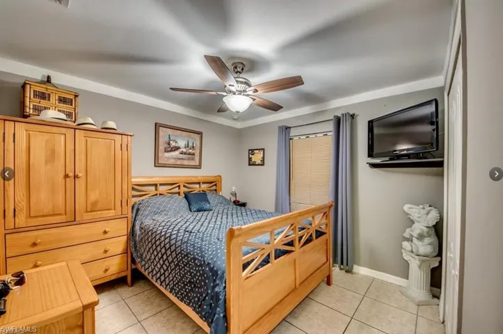 Bedroom with light tile patterned floors, a ceiling fan, and ornamental molding