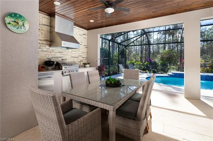View of patio with a lanai, outdoor dining area, an outdoor pool, ceiling fan, and a sunroom