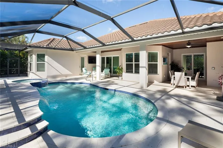 View of pool with a patio, a sunroom, a lanai, a pool with connected hot tub, and outdoor dining area