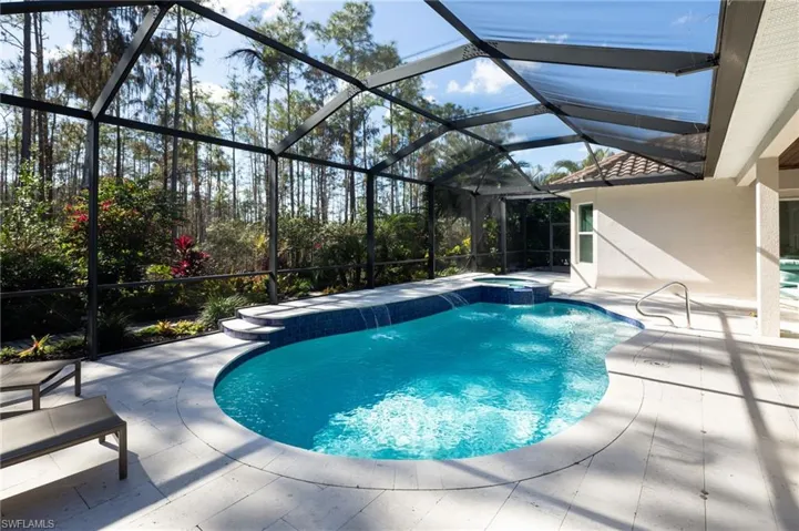View of swimming pool with a patio, a sunroom, a pool with connected hot tub, and a lanai