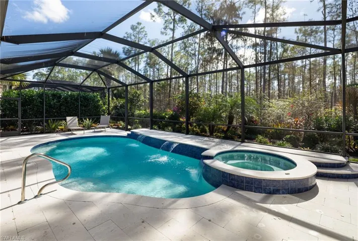 View of swimming pool featuring a lanai, a pool with connected hot tub, a patio area, and a sunroom