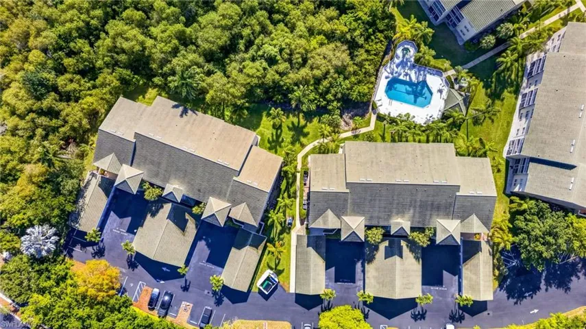 Aerial perspective showcasing multiple properties amidst lush green landscaping