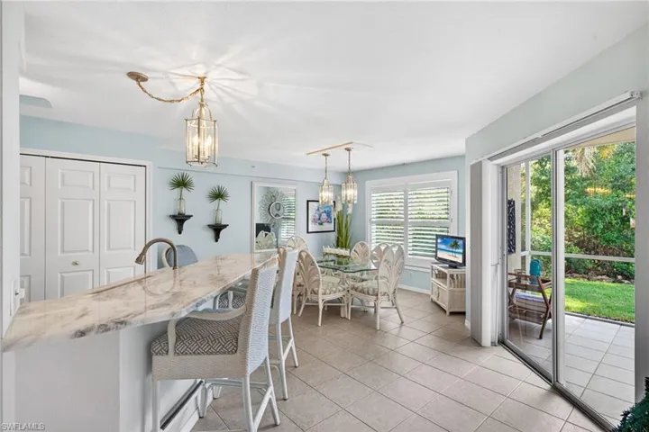 Spacious breakfast bar with a stone countertop, tile flooring, and direct access to an outdoor patio through sliding glass doors