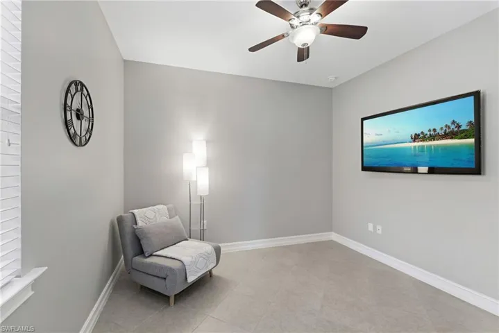 Bedroom three, conveniently situated near the front entrance, offers a ceiling fan, tile flooring, and a front-facing window.