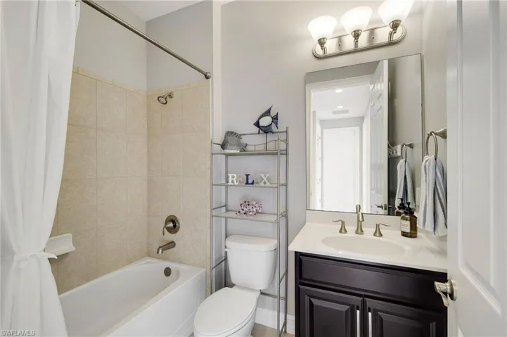 A view of the full bathroom near bedroom two, featuring a tub/shower combo and single vanity.