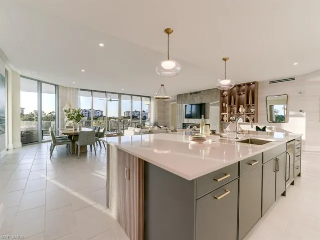 Kitchen with an island with sink, open floor plan, floor to ceiling windows