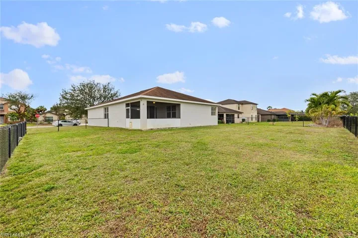 Back of house featuring a fenced backyard and stucco siding