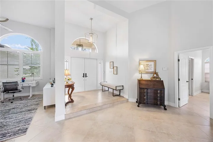 Foyer featuring high vaulted ceiling, plenty of natural light, and light tile patterned floors