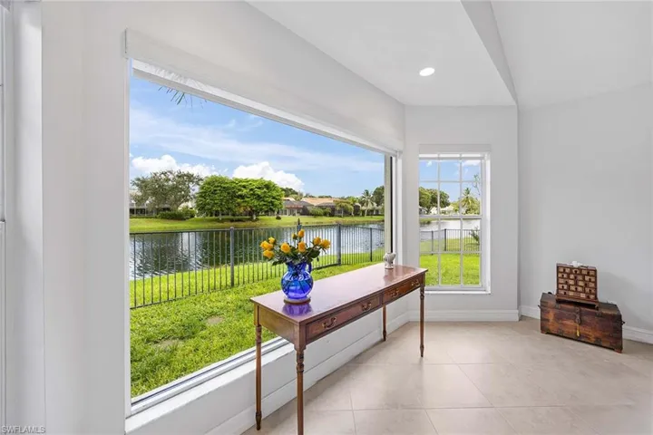 Tiled office space featuring a water view and recessed lighting