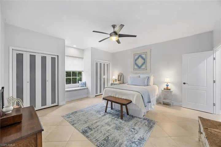 Bedroom featuring multiple closets, ceiling fan, light tile patterned floors, and recessed lighting