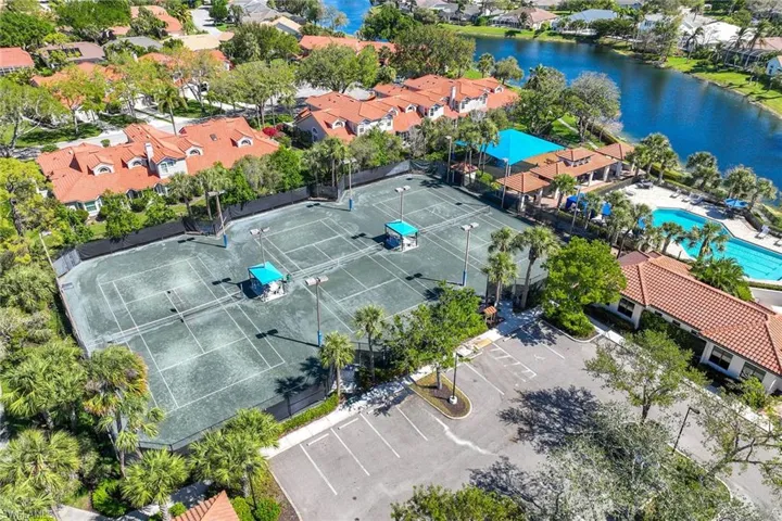 Aerial view of residential area with a nearby body of water and a pool area
