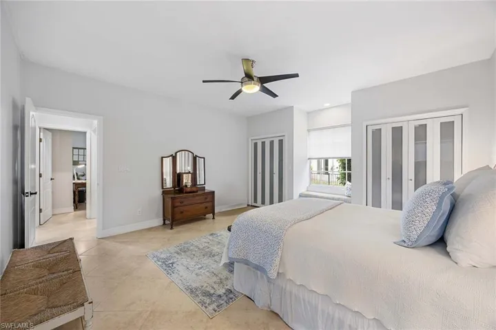 Bedroom featuring multiple closets, a ceiling fan, and light tile patterned flooring