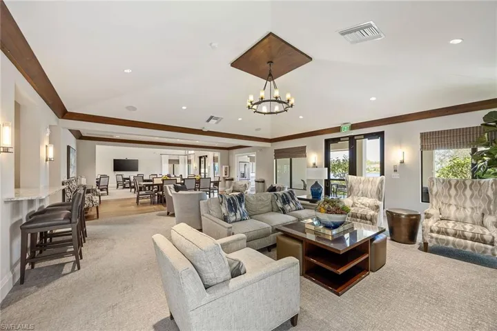Living area with light colored carpet, recessed lighting, crown molding, and a chandelier