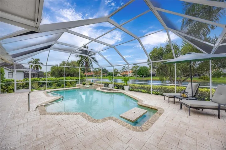 Swimming pool with a sunroom, a lanai, a water view, and a patio area