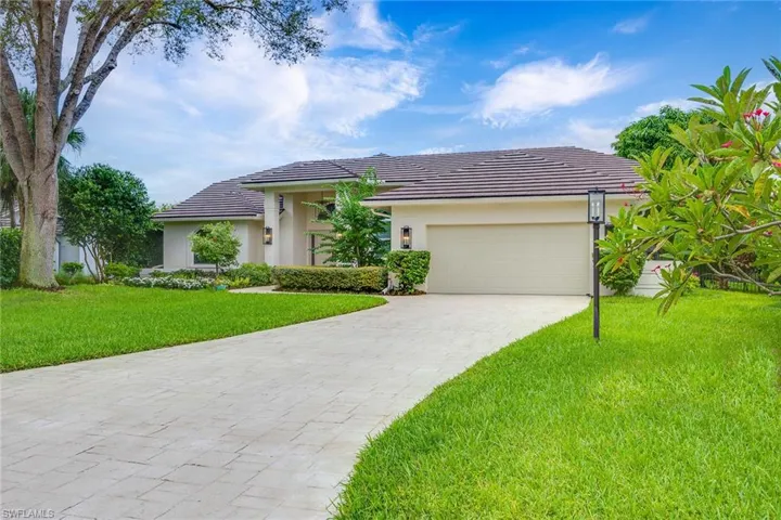 Prairie-style home featuring a front lawn, decorative driveway, an attached garage, and a tiled roof