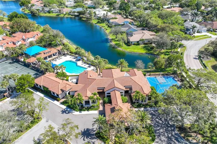 Aerial perspective of suburban area featuring a large body of water and a pool