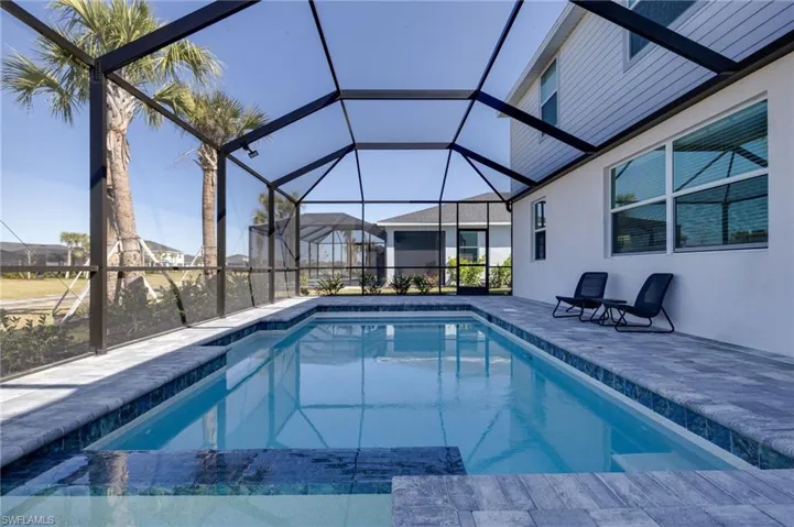 Integrated pool / spa with a sunroom, a lanai, and a patio
