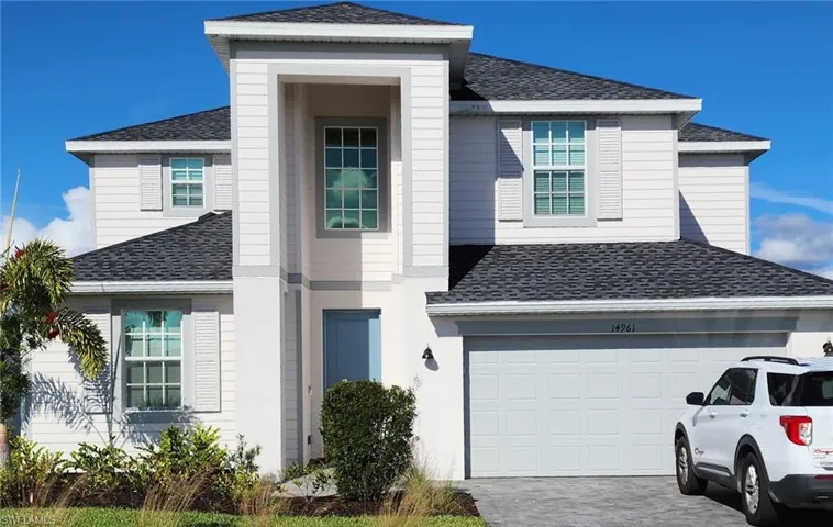 View of front of home featuring roof with shingles and decorative driveway