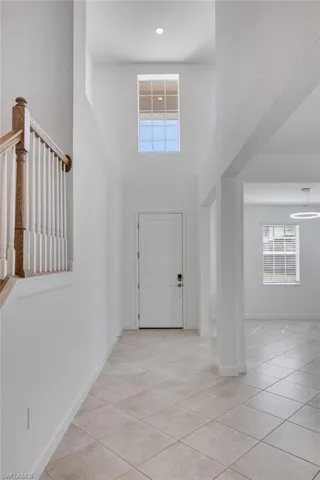 Entryway featuring a high ceiling and light tile patterned flooring