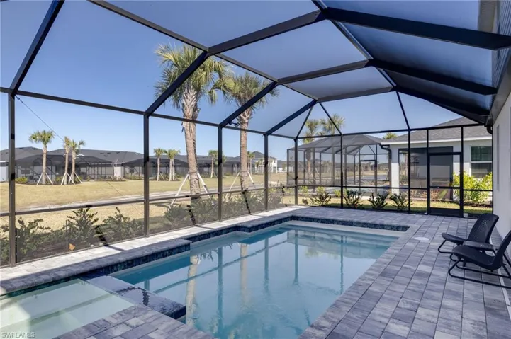 Swimming pool featuring a sunroom, a lanai, a patio area, and a residential view
