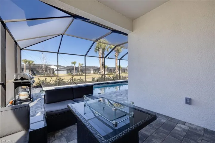 View of patio with an outdoor hangout area, area for grilling, a sunroom, a lanai, and an outdoor pool