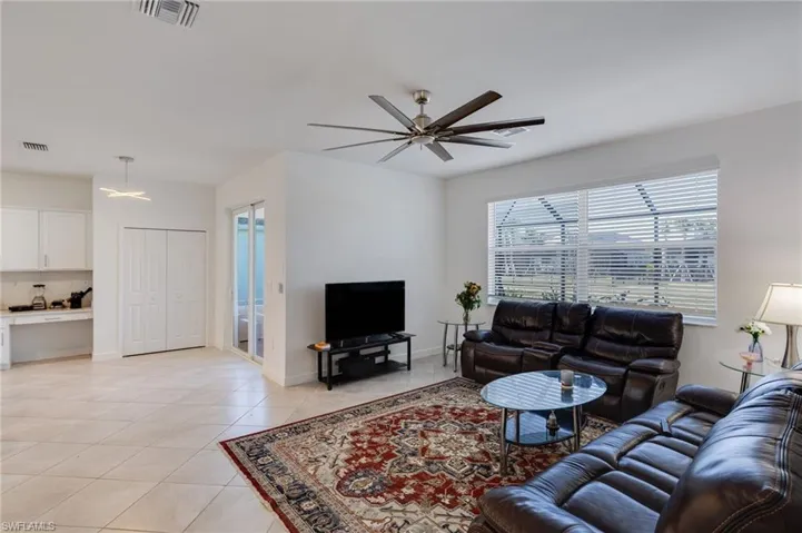 Living area with a ceiling fan and light tile patterned flooring