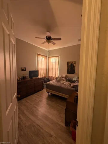 Bedroom with dark wood-style flooring and a ceiling fan