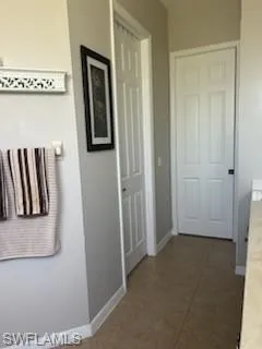 Bathroom with baseboards and dark tile patterned flooring