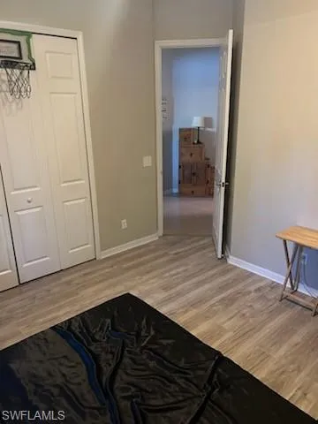 Unfurnished bedroom with light wood-style floors and a closet