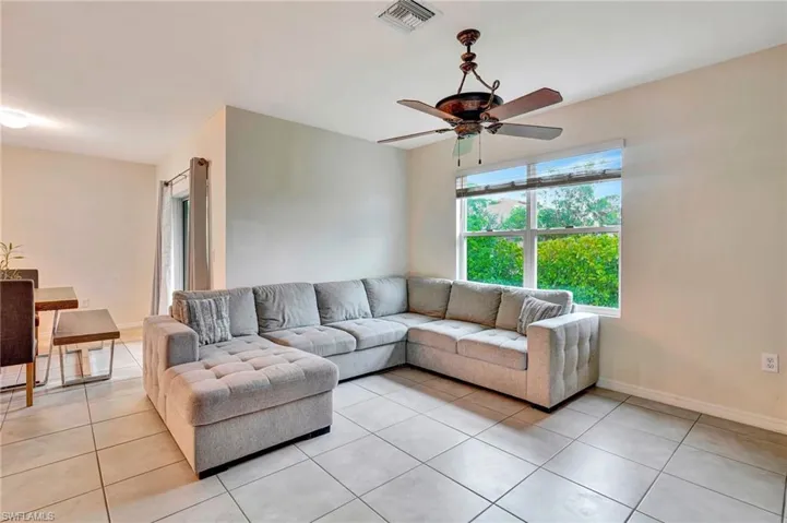 Living room featuring ceiling fan and light tile floors