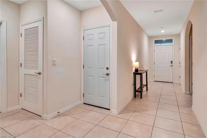 Corridor featuring light tile flooring