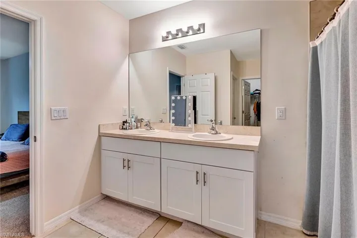 Bathroom with tile floors, large vanity, and double sink