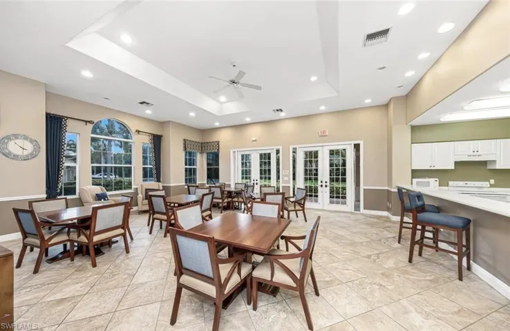 Dining space featuring french doors, a tray ceiling, healthy amount of natural light, a ceiling fan, and recessed lighting