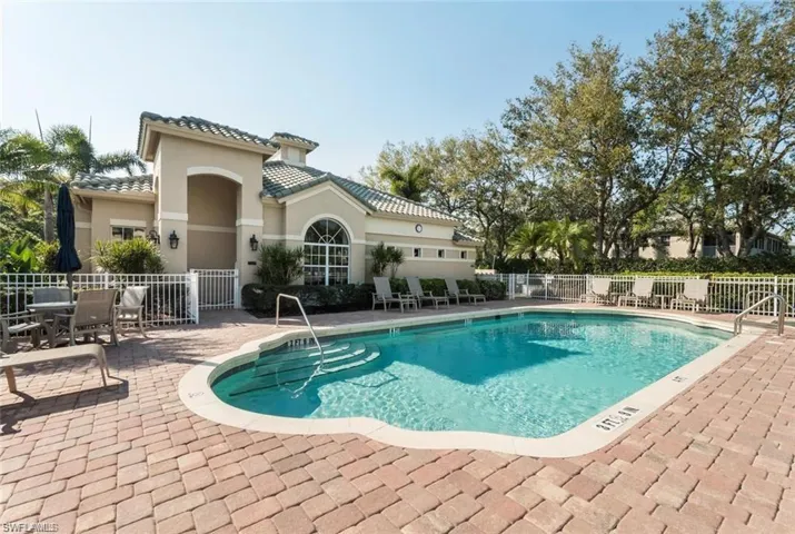 Community pool with a patio and outdoor dining space