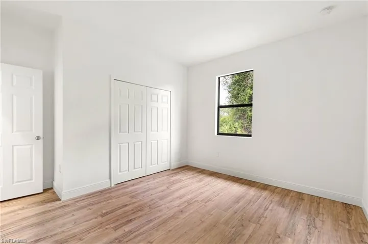 Unfurnished bedroom with light hardwood / wood-style flooring and a closet