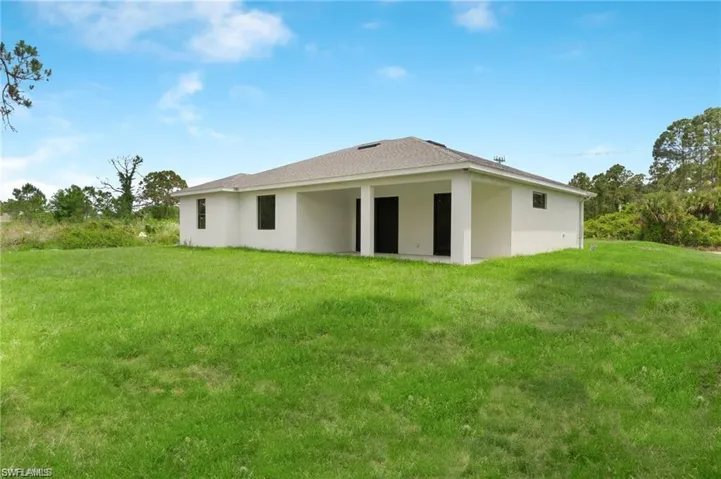 Back of house with a yard