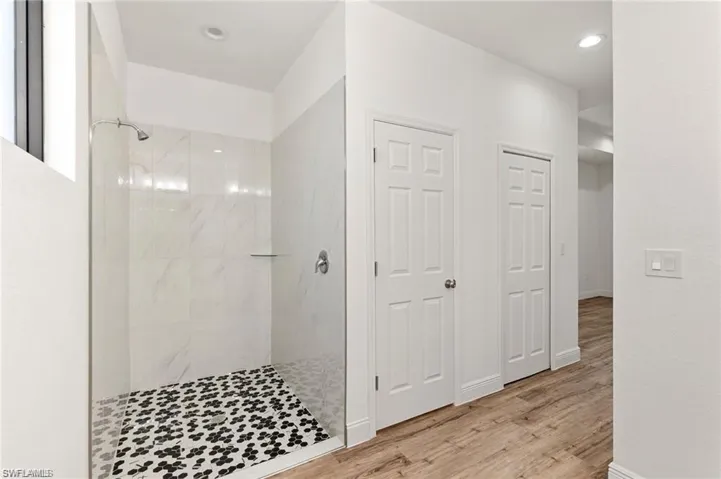 Bathroom featuring tiled shower and hardwood / wood-style flooring