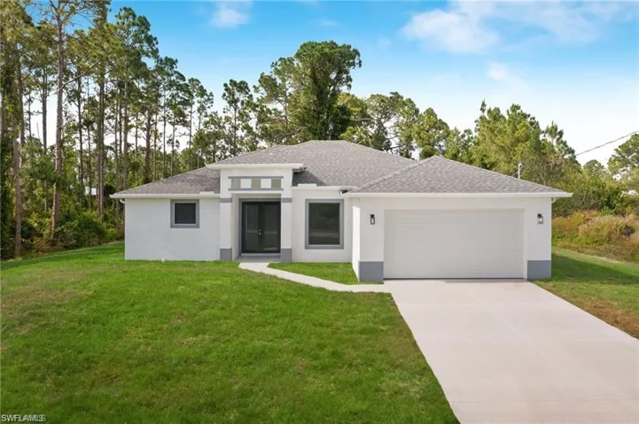 View of front facade featuring a garage and a front yard