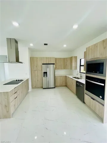 Kitchen with island exhaust hood, dishwasher, stainless steel fridge with ice dispenser, light brown cabinets, and oven